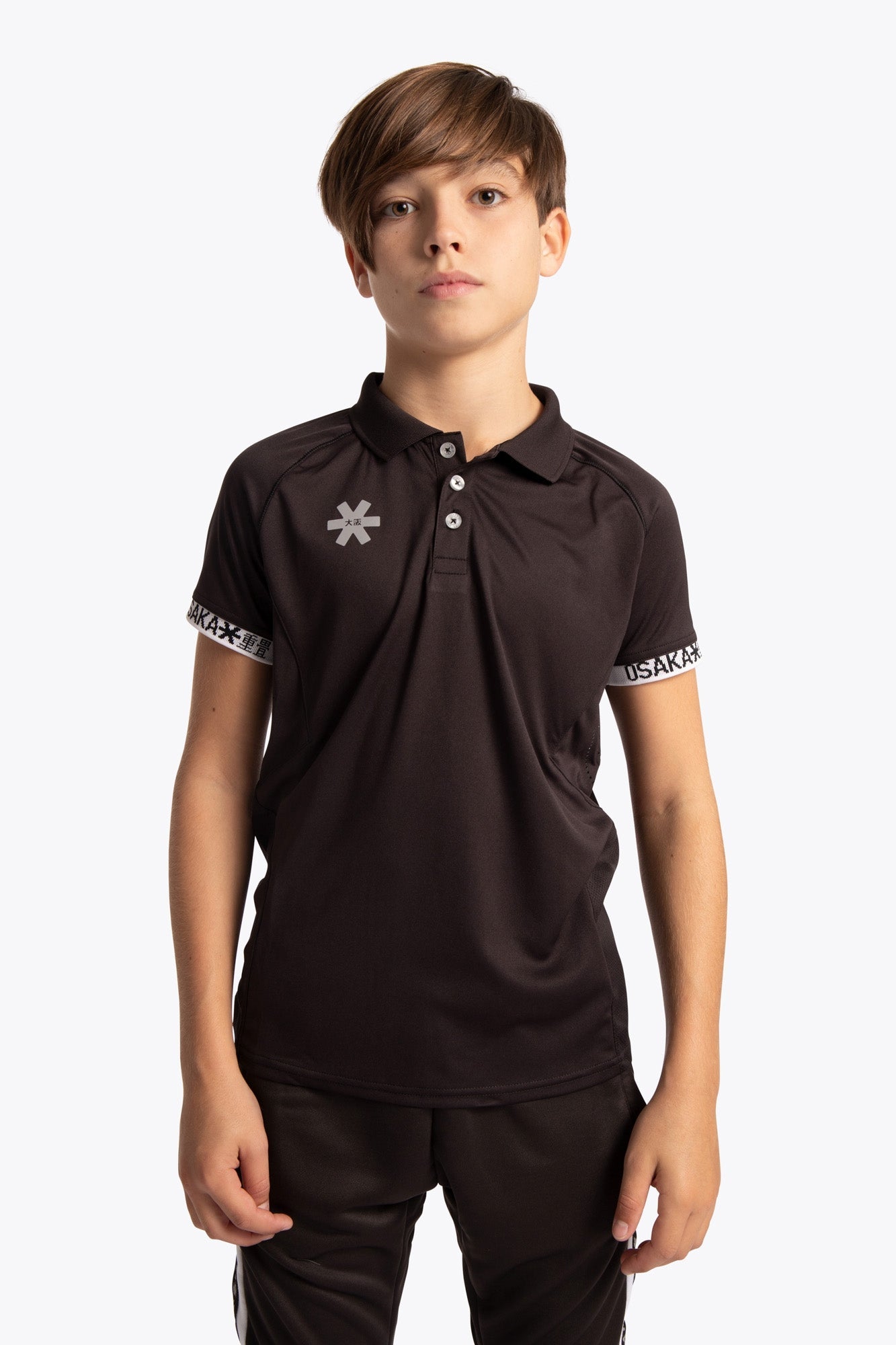 Boy wearing the Osaka Kids Polo Jersey in Black. Front view