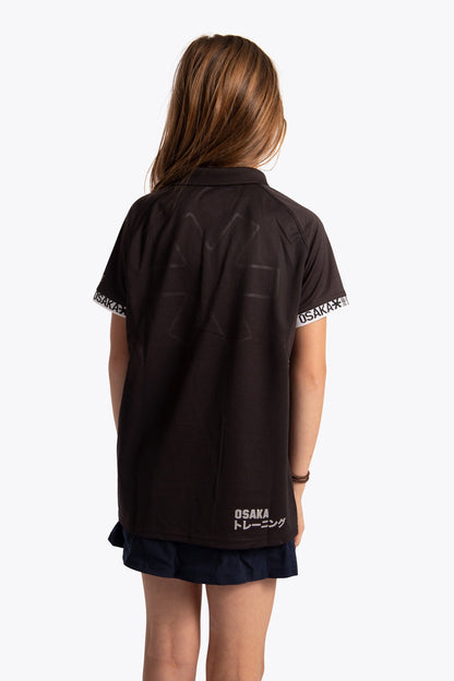 Girl wearing the Osaka Kids Polo Jersey in Black. Back view