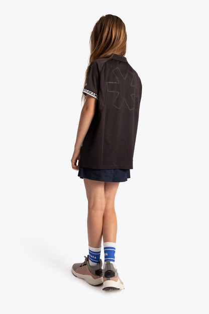 Girl wearing the Osaka Kids Polo Jersey in Black. Back view