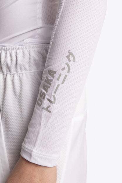 Model wearing the Osaka Kids Baselayer Top in white. Front detail sleeve view