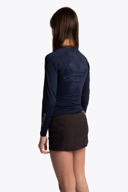Girl wearing the Osaka Kids Baselayer Top in Navy. Back view