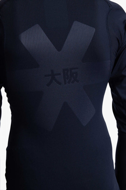 Model wearing the Osaka Kids Baselayer Top in Navy. Back view