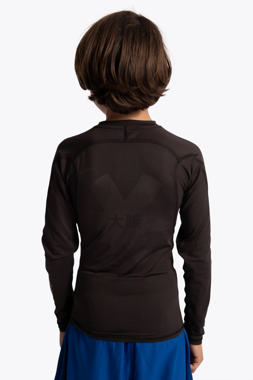 Kid wearing the Osaka Kids Baselayer Top in Black. Back view