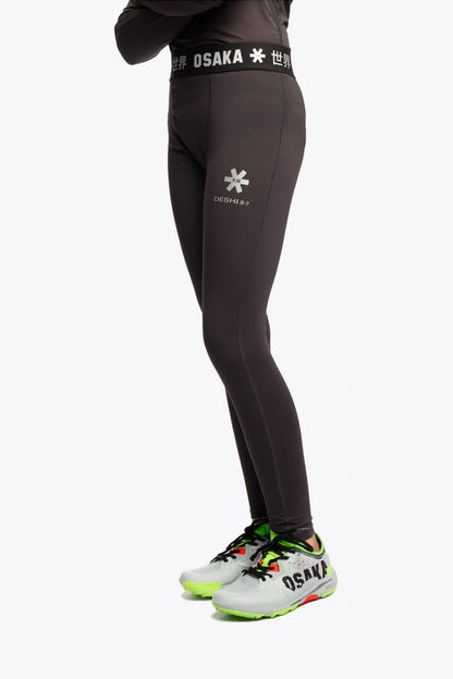 Model wearing the Osaka Kids Baselayer Tights in Black. Side view